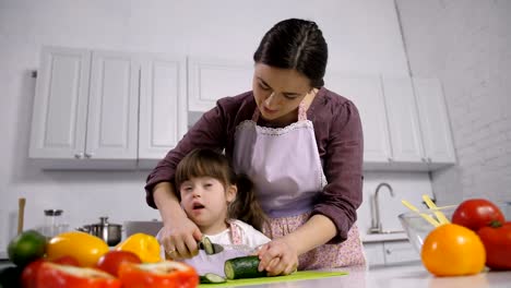 Niño-con-discapacidad-síndrome-de-down-con-madre-cocina