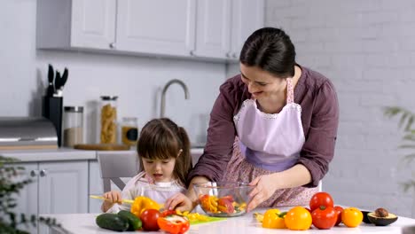 Mädchen-mit-besonderen-braucht-Mutter-Salat-vorbereiten-helfen