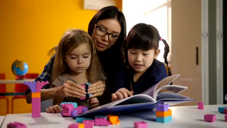 Lovely-daycare-teacher-working-with-pupils-at-class