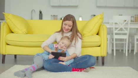 Carefree-mom-and-girl-playing-online-with-tablet-pc