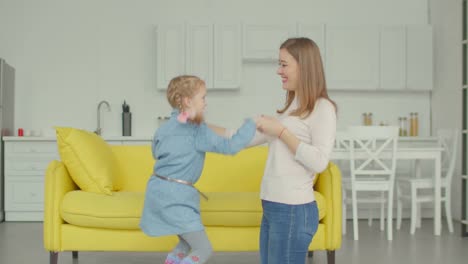 Alegre-niña-con-madre-bailando-juntos