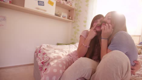 Girls-on-a-bed-holding-each-other's-hair-as-moustaches