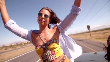 Road-Trip-boho-girl-dances-in-convertible-car-during-road-trip