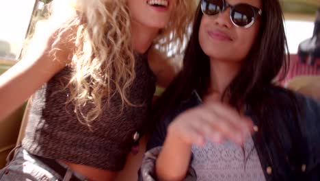 Two-Hipster-Girls-friends-Sitting-Together-dancing-in-Retro-Van