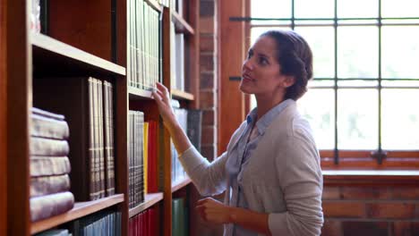 Librarian-looking-for-a-book-and-smiling-at-camera