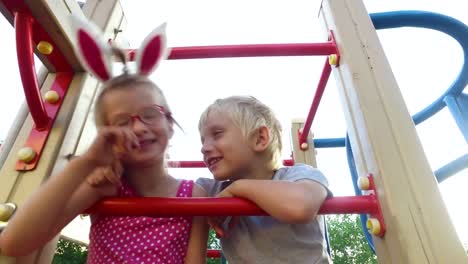 Girl-with-ears-and-glasses-and-boy-with-white-hair-having-fun-on-the-children's-tower.