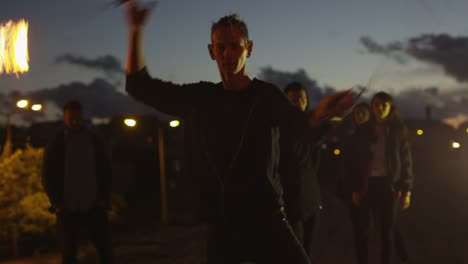 Male-Artist-Performing-Fire-Show-Outdoors-at-Evening-Time.