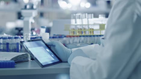 Senior-male-scientist-is-using-a-tablet-computer-in-a-laboratory.