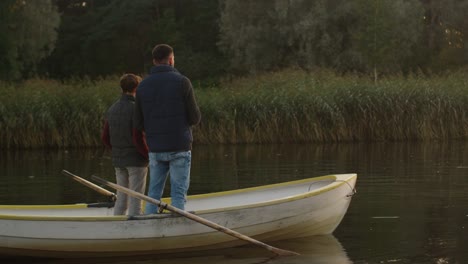 Padre-e-hijo-están-de-pie-en-el-barco-y-pesca.