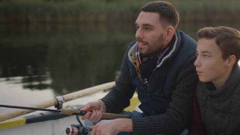 Vater-lehrt-seinen-Sohn-Angeln.-Beide-sitzen-im-Boot.