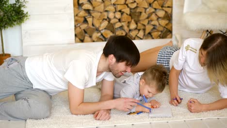 Padre-madre-madre-ayudando-a-su-hijo-dibujar-en-su-sala-de-estar