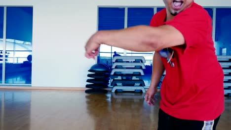 Cool-hombre-en-gorra-y-gafas-de-sol-bailando-el-hip-hop-en-el-gimnasio