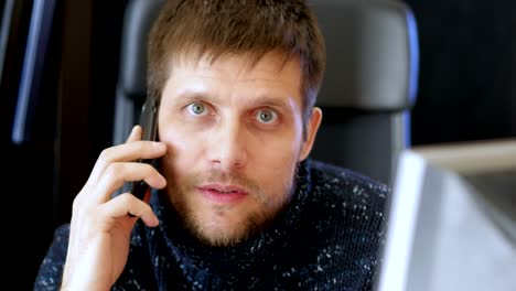 Man-using-computer-and-talking-on-cell-phone.