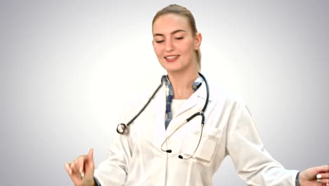 Smiling-young-woman-in-a-good-mood-making-funny-dance-on-white-background