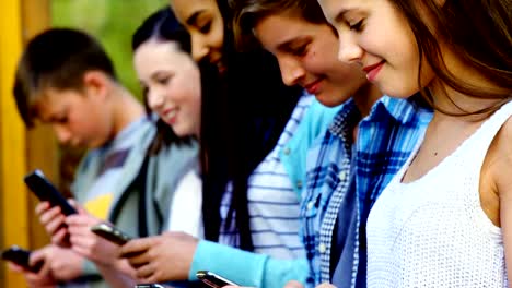 Gruppe-von-Schulfreunden-mit-Mobiltelefon-außerhalb-der-Schule