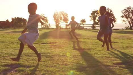 Niños-de-primaria-jugando-con-un-balón-de-fútbol-en-un-campo