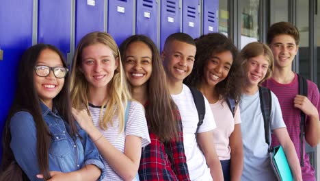 Niños-de-la-escuela-adolescente-sonriendo-a-la-cámara-en-el-corredor-de-la-escuela