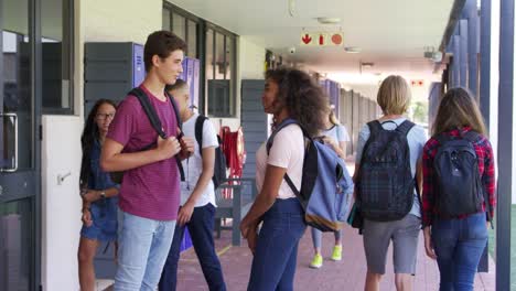 Teenage-Klassenkameraden-stehen-im-Gymnasium-Flur-sprechen