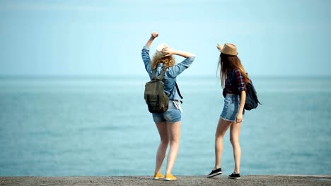 Young-women-enjoying-and-dancing-on-a-sea-shore.