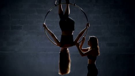 Das-Mädchen-hilft-ihrem-Partner-den-Trick-der-aerial-Hoop