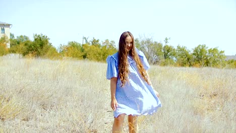 Una-mujer-joven-con-el-pelo-largo-está-bailando-en-medio-del-campo.