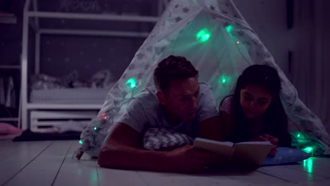 Padre-cariñoso-leyendo-a-cuentos-de-hadas-con-su-pequeña-hija