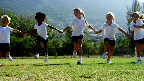 School-kids-holding-hands-and-running-in-park