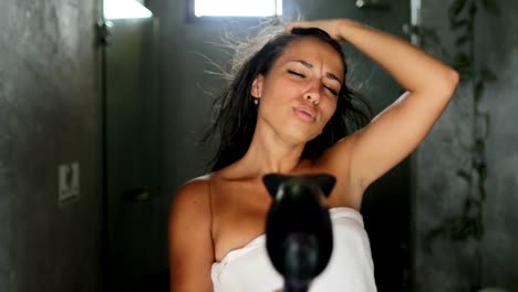 Mujer-en-el-baño-canto-seque-el-cabello-con-secador,-encantadora-alegre-hermosa-chica-en-toalla-feliz-sonriendo