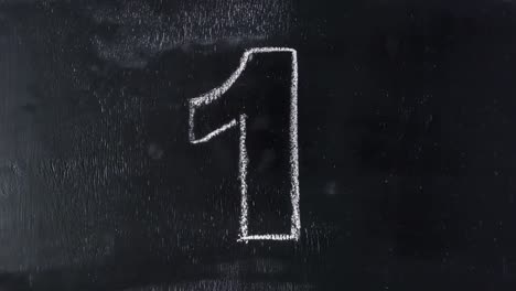 Stop-motion-animation-of-hand-drawing-countdown-numbers-on-black-chalkboard.-4k-movie-timelapse