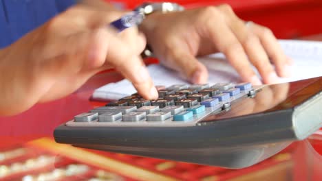 Businessman-is-calculating-by-use-finger-press-button-on-calculator