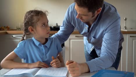 Father-helping-daughter-with-homework-at-home.