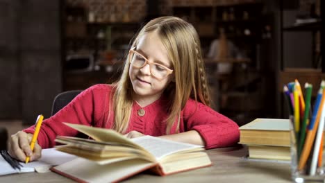 Smiling-teenage-girl-studying-lessons-at-home