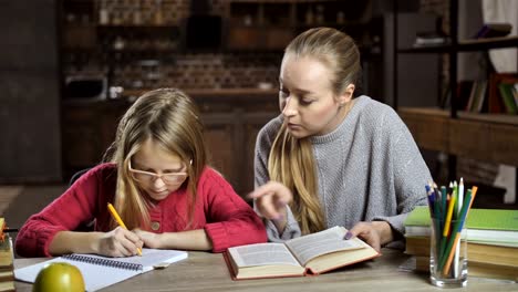 Mutter-ihre-Tochter-bei-den-Hausaufgaben-zu-Hause-helfen