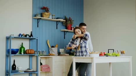 Attraktives-junges-Paar-fröhlich-tanzen-beim-Kochen-in-der-Küche-zu-Hause