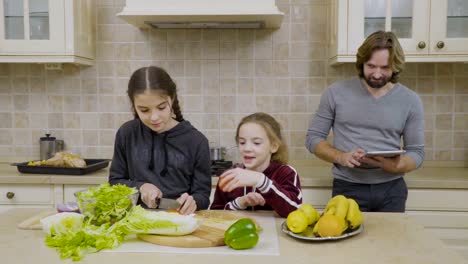 Zwei-kleine-Mädchen-lernen,-einen-Salat-zu-machen