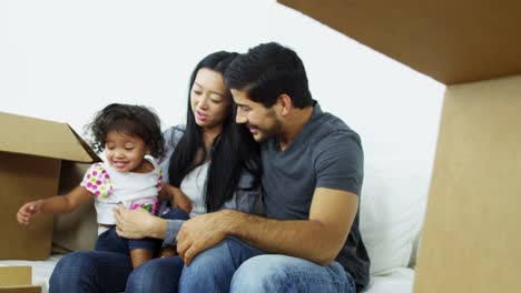 Ethnische-Eltern-spielen-Baby-Mädchen-im-neuen-Zuhause