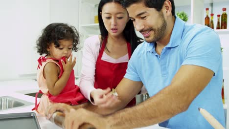 Ethnic-pre-school-girl-parents-baking-home-kitchen