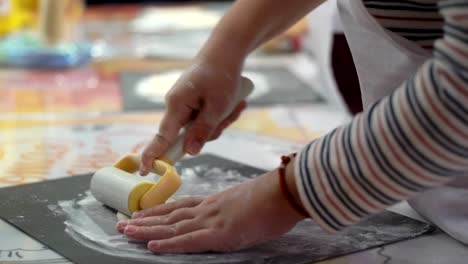 Baby-Hand-kleine-Köche-Torte-aus-Mehl-und-Teig-unter-Anleitung-eines-erfahrenen-Lehrers-kocht,-Nahaufnahme,-master-Klasse-Unterricht-Gruppe-Kinder-kochen-Kuchen-mit-ihren-Eltern-Teil-vier