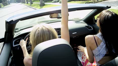 Beautiful-Caucasian-girl-friends-driving-open-top-car