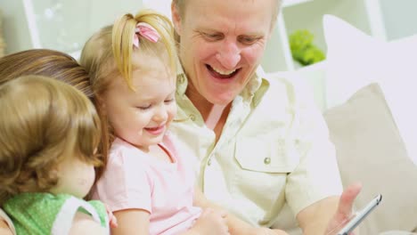 Parents-and-daughters-playing-touchscreen-game-on-tablet