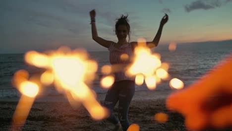 teenager-girl-with-sparklers-dancing-on-the-beach.-shot-in-slow-motion