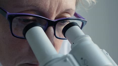 Female-scientist-looking-through-microscope