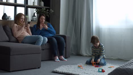 Attractive-women-relaxing-on-couch-with-smartphones