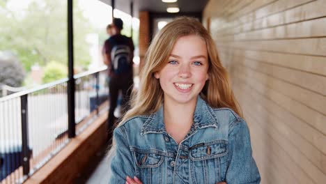 Portrait-Of-Female-Student-Walking-Into-Focus-Outside-Building