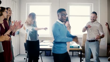 Happy-African-American-businessman-dancing.-Casual-man-celebrates-victory-and-achievement-with-mixed-race-colleagues-4K