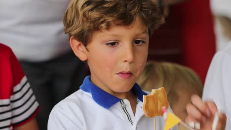 Young-boy-holding-cookie.-Candid-4K-clip-of-child-at-a-children-party-eating-sweets