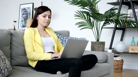 Casual-Sitting-Woman-Listening-Music-on-Laptop-at-Home