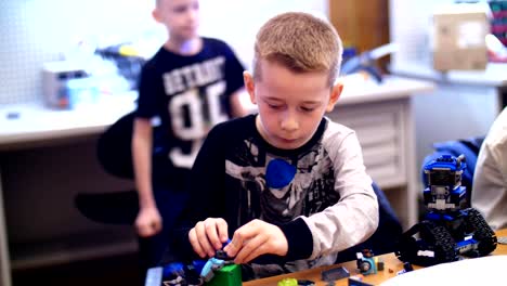 el-niño-de-10-años,-juega-en-el-diseñador-de-cubos,-placas,-circuitos,-cables.-un-pequeño-inventor-crea-robots,-máquinas-de-diferentes-partes-del-diseñador