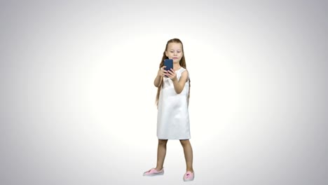 Happy-little-girl-take-a-selfie-with-a-smart-phone-on-white-background