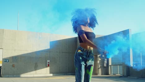 Young-woman-dancing-outside-with-smoke-grenade-at-sunset-on-rooftop-parking-garage